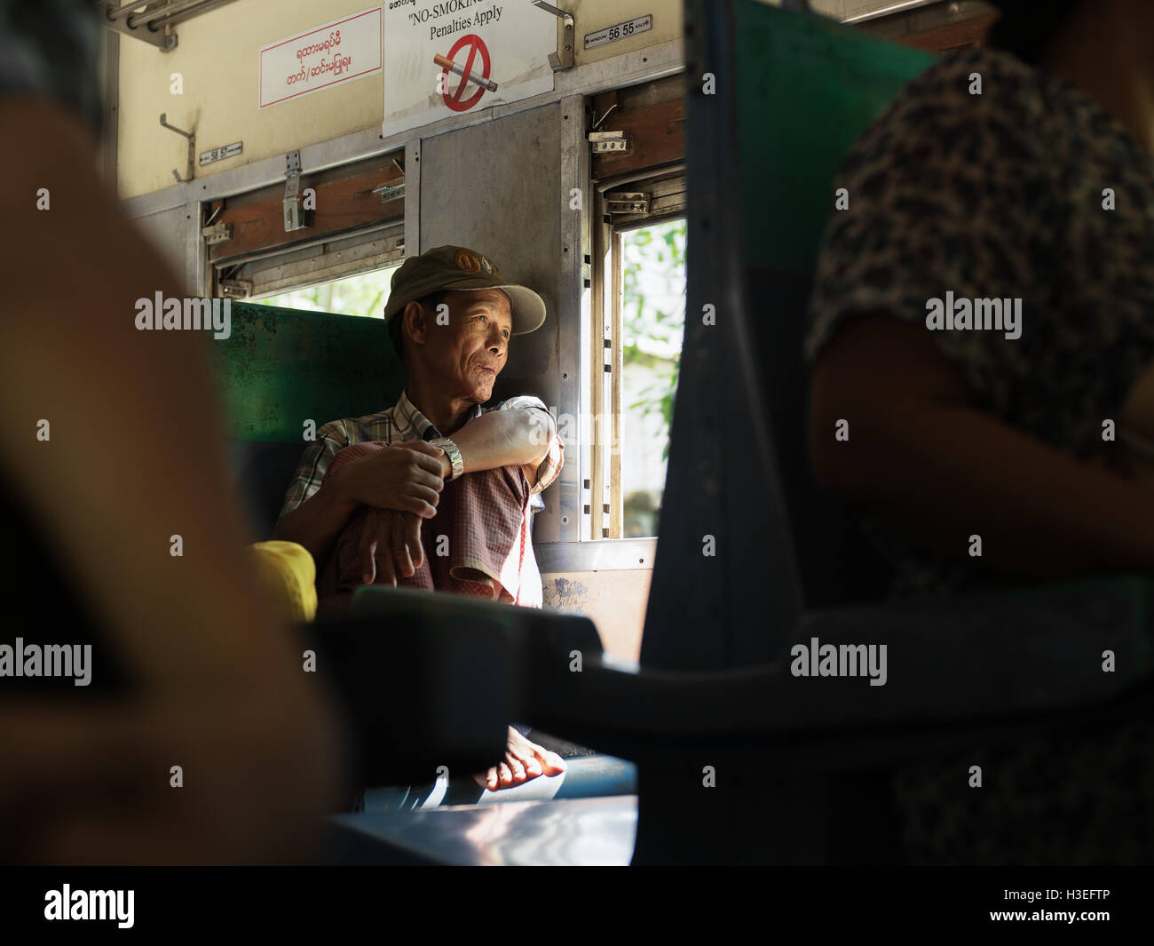 Un homme regarde par la fenêtre sur la ligne Circle train à Yangon, Myanmar (Birmanie) Banque D'Images