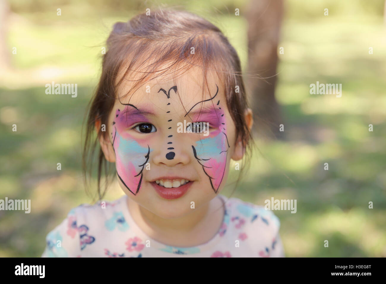 Cute girl face se peint comme un papillon Banque D'Images