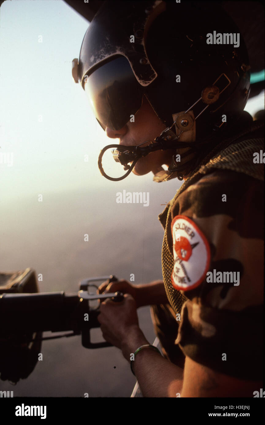 Le nord de la province de MORAZAN, EL SALVADOR, mars 1984 : Porte-gunner sur un hélicoptère de l'armée salvadorienne portant un badge de Soldier of Fortune sur son épaule. Banque D'Images