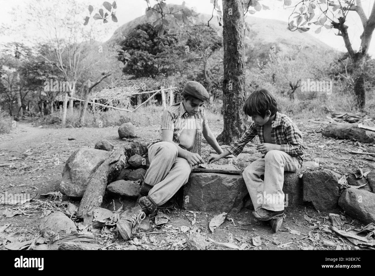 CHALATENANGO, EL SALVADOR, février 1984 : - dans le FPL Les zones de contrôle les garçons jouent un jeu de plateau. Photo de Mike Goldwater Banque D'Images