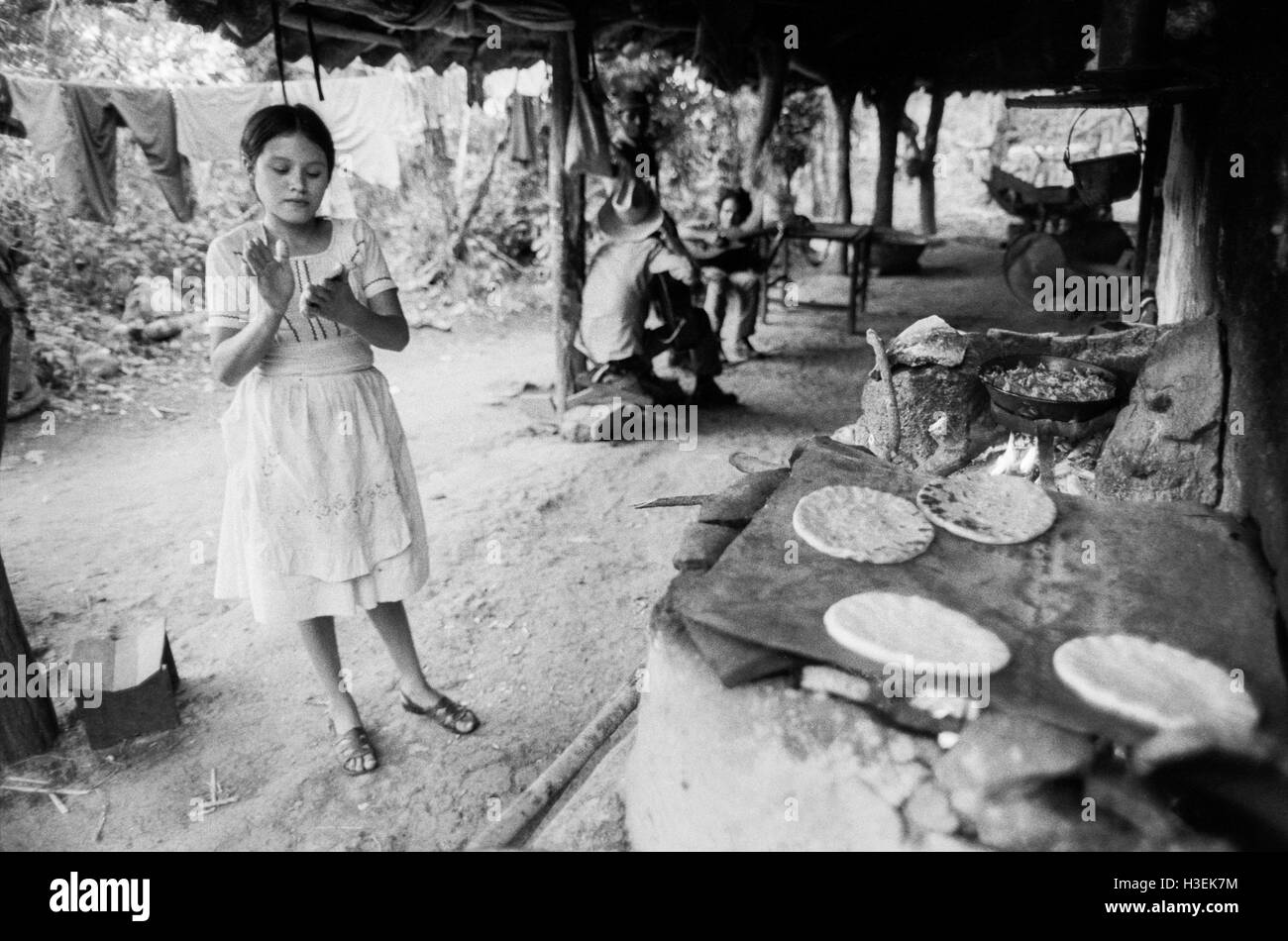 CHALATENANGO, EL SALVADOR, février 1984 : - dans le FPL Les zones de contrôle une jeune femme des tortillas, l'aliment de base local. Banque D'Images