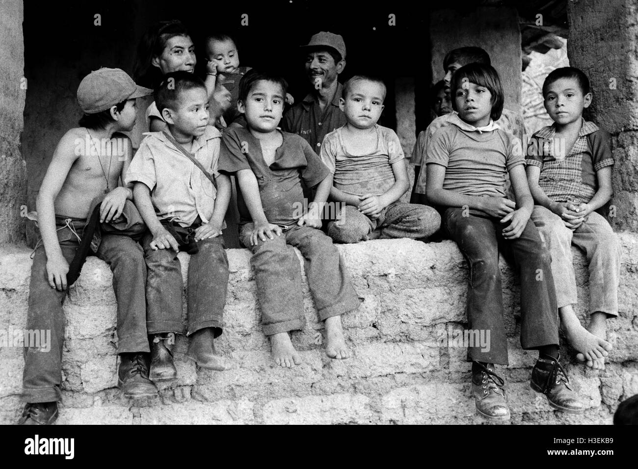 CHALATENANGO, EL SALVADOR, février 1984 : - dans le FPL Les zones de contrôle Les enfants sont assis sur un wll pour écouter un concert de musique locale. Photo de Mike Goldwater Banque D'Images