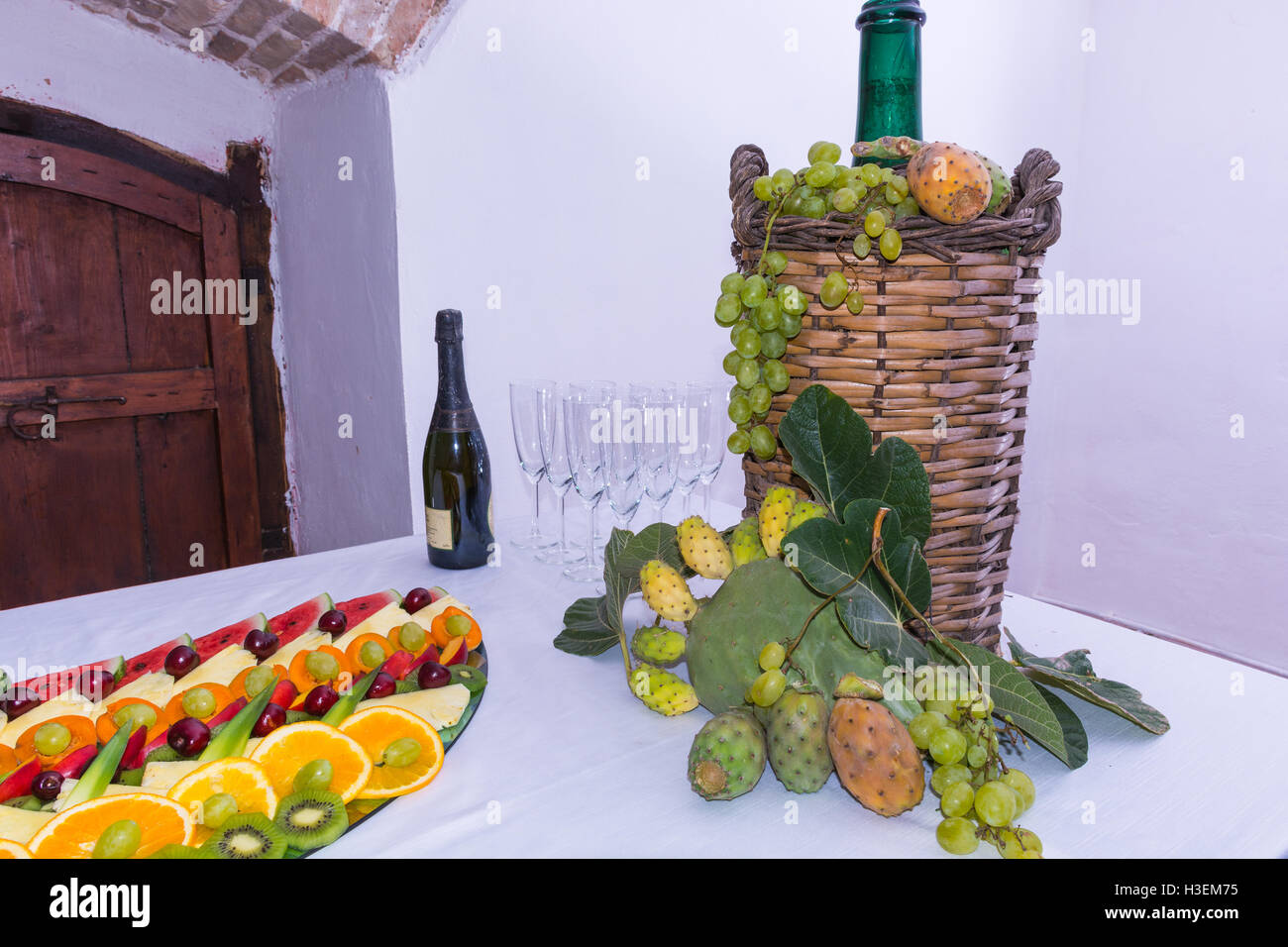 Bonbonne en verre, osier, doublée pour le vin. Sur une table laden avec un  restaurant, avec des raisins, des figues, de figuiers de barbarie et de  feuilles. Une bouteille de vin et des verres Photo Stock - Alamy