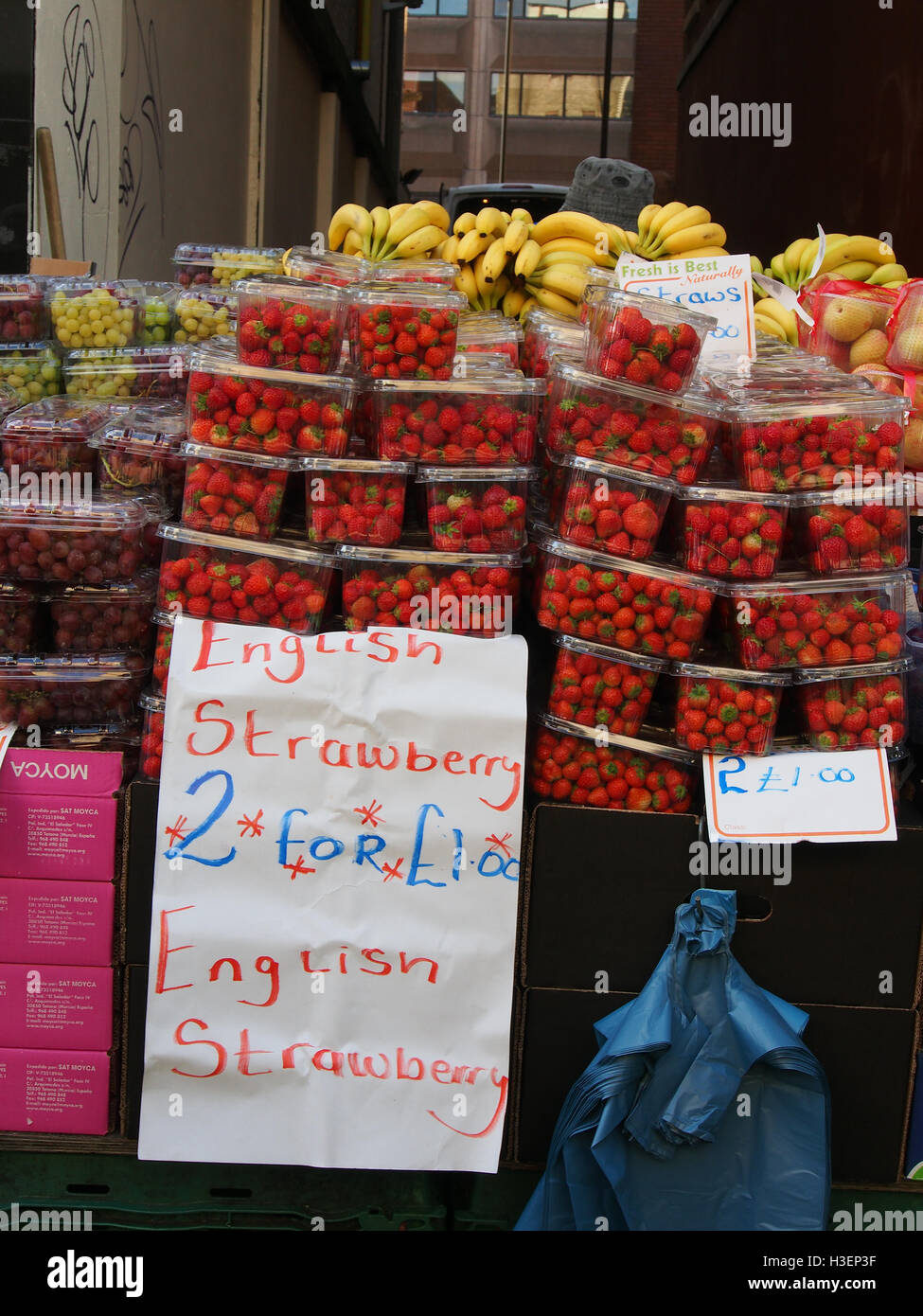 Décrochage du marché de fortune vendant des fruits sur la high street, dans le centre de Manchester, avec l'anglais les fraises à la vente à la hauteur de la saison. Banque D'Images