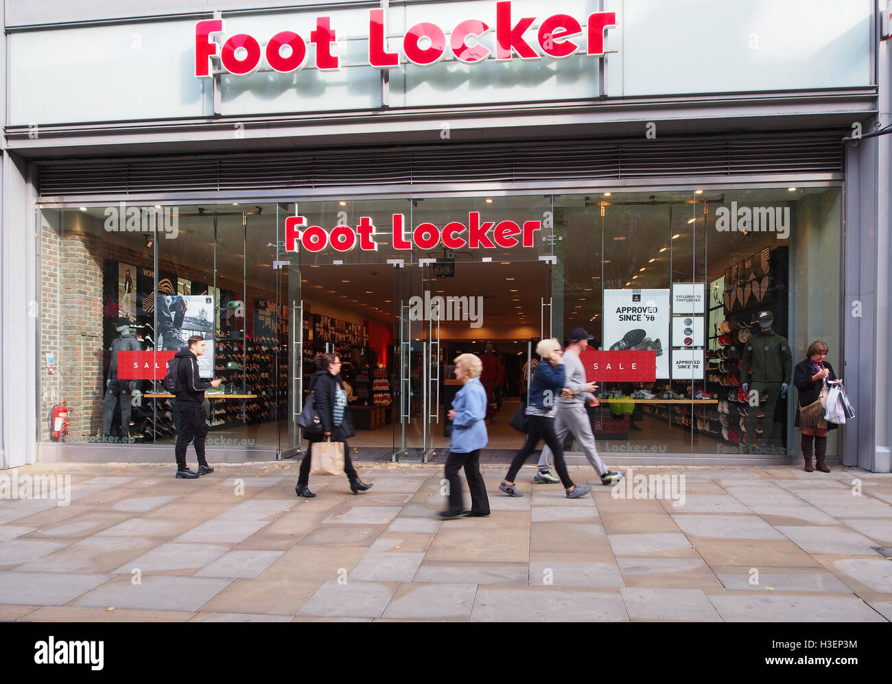 Magasin de chaussures Foot Locker dans le centre de Manchester, en  Angleterre, Royaume-Uni, avec six personnes à pied et passé un sale sign  dans la vitrine Photo Stock - Alamy