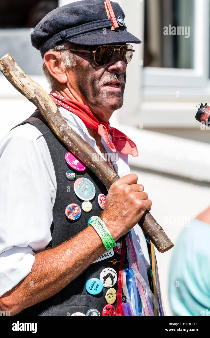 Festival de la semaine folklorique de Broadstairs. Cheval mort Morris man carrying poteau en bois contre l'épaulement, vue latérale. Close-up. Blacked traditionnels font face. Banque D'Images