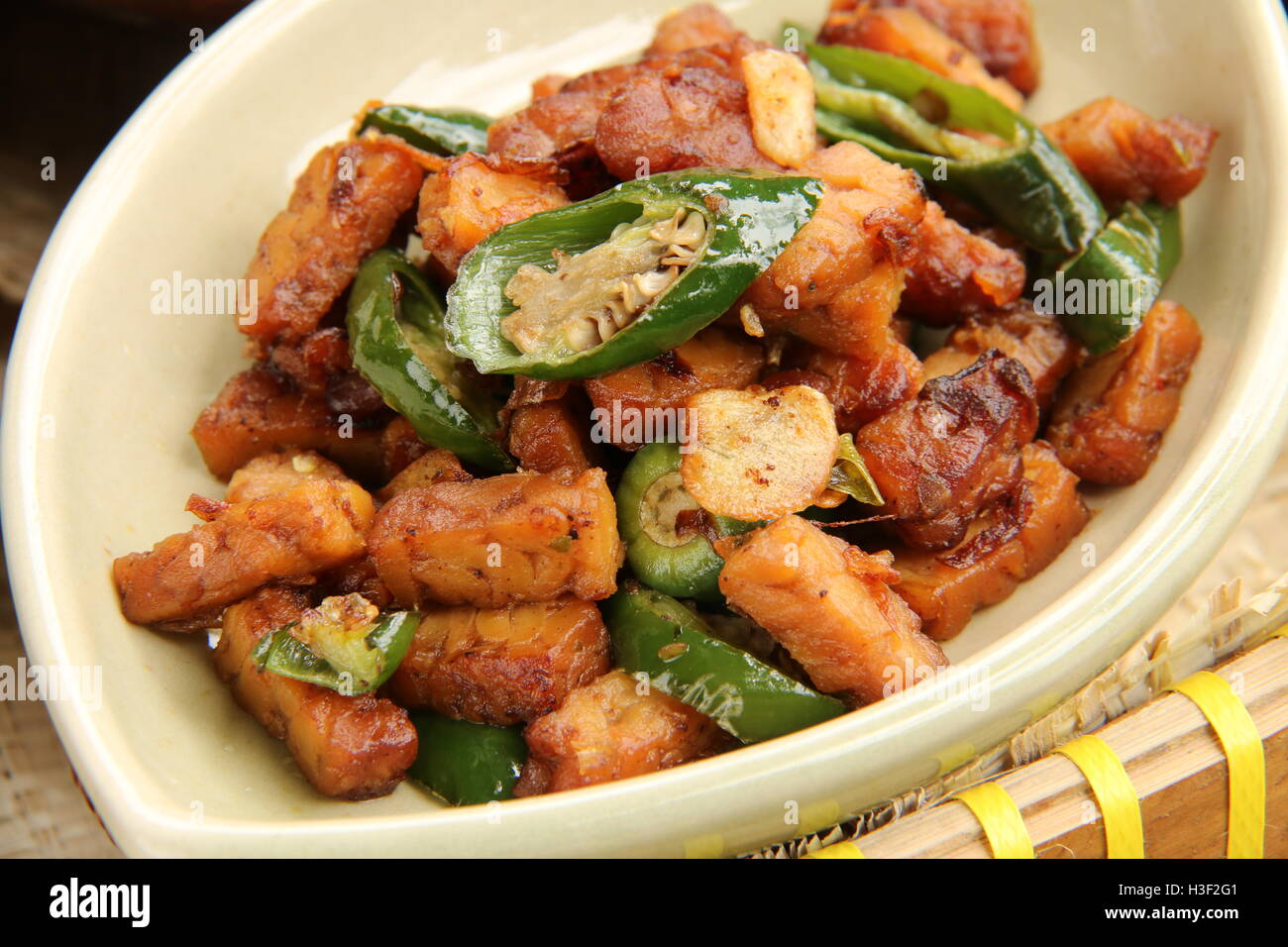 Tempeh sauté (tourteaux de soja) avec piment vert doux et sauce de soja. Banque D'Images