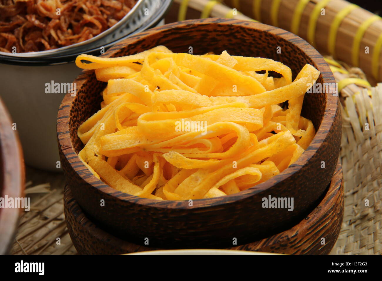 Julienne de omelette. Garniture pour commun Nasi Uduk Betawi. Placé dans un arenga-bol en bois. Banque D'Images