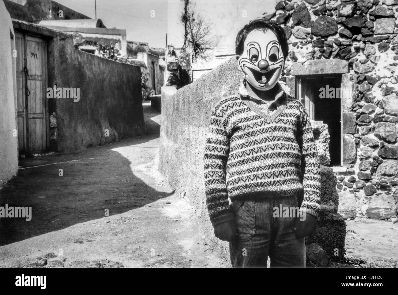 Un garçon dans un masque de clown sur Santorini Banque D'Images
