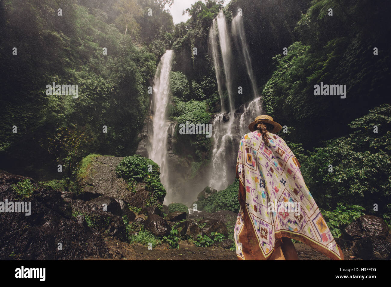 Vue arrière shot of female tourist à marcher en direction de cascade dans la forêt tropicale. Jeune femme sur une maison de vacances dans la nature. Banque D'Images