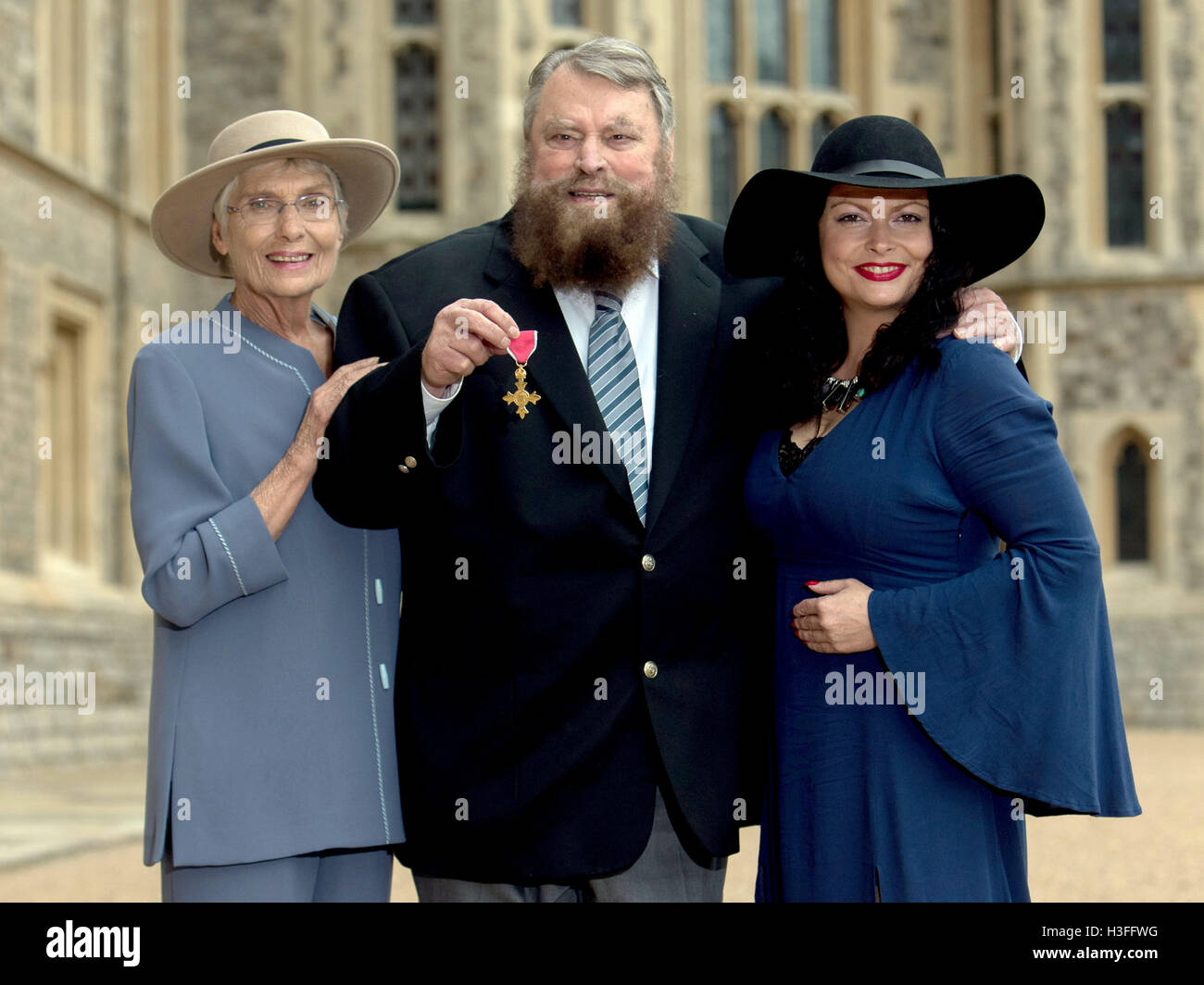 Acteur brian blessed, avec sa femme Hildegard et sa fille Rosalind, après qu'il est fait officier de l'ordre de l'Empire britannique (OBE) par la reine Elizabeth II lors d'une cérémonie au Château de Windsor. Banque D'Images