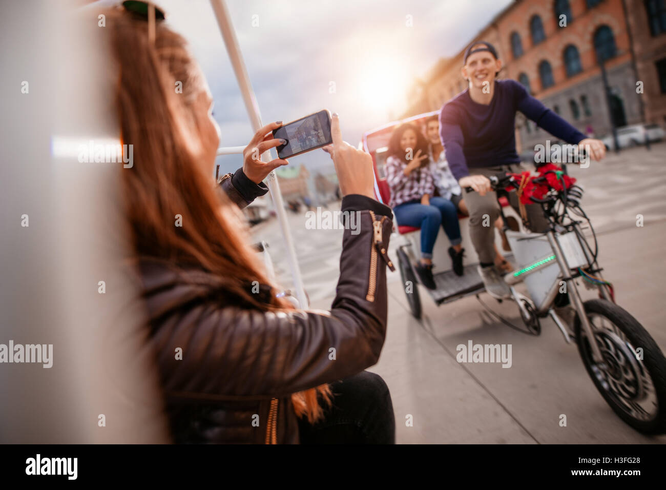 Les femmes prenant des photos d'amis sur le trajet en tricycle. Bénéficiant d'Amis de vacances. Banque D'Images