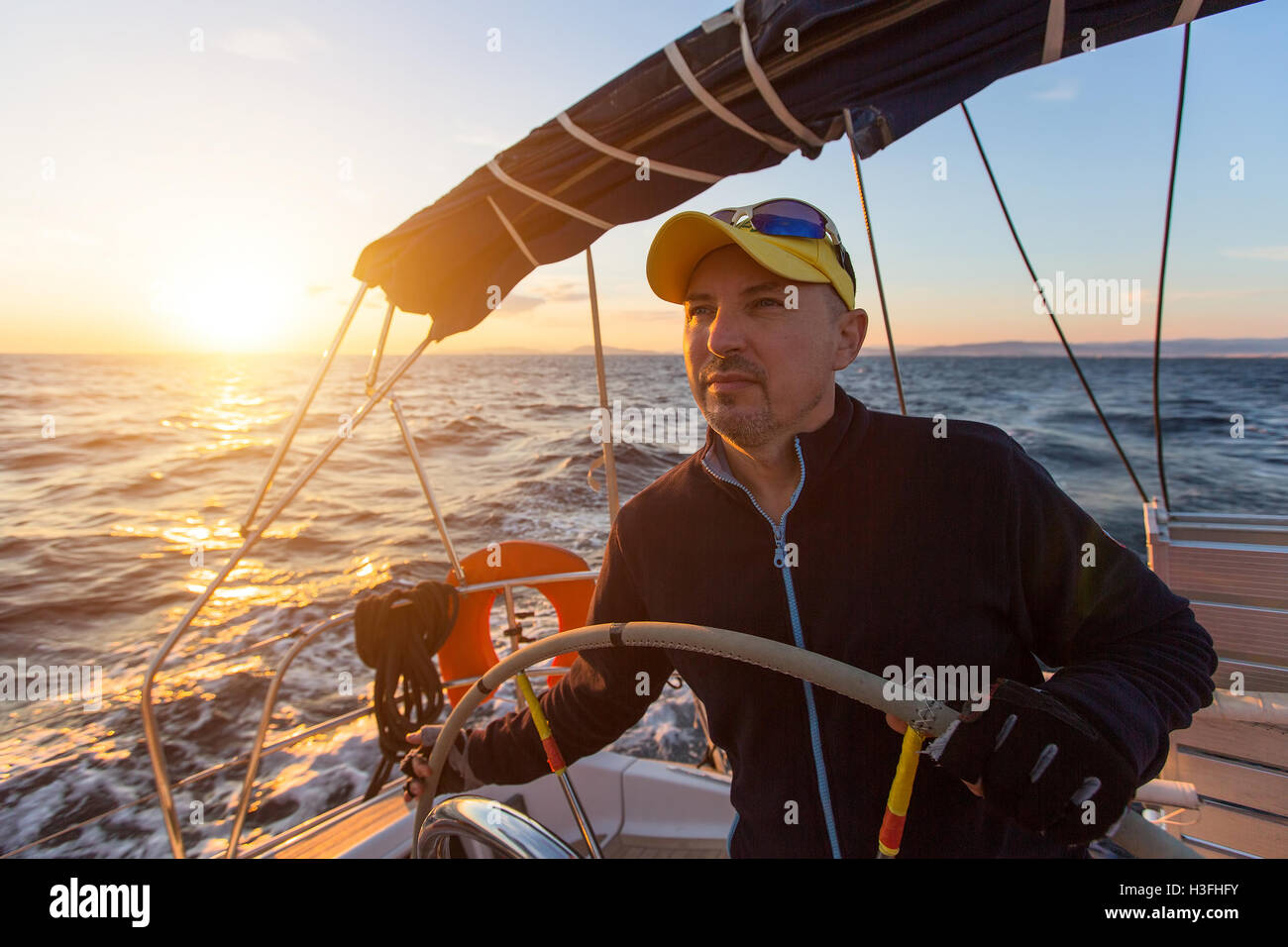 Skipper entraîne le bateau à voile dans la mer Egée. Banque D'Images