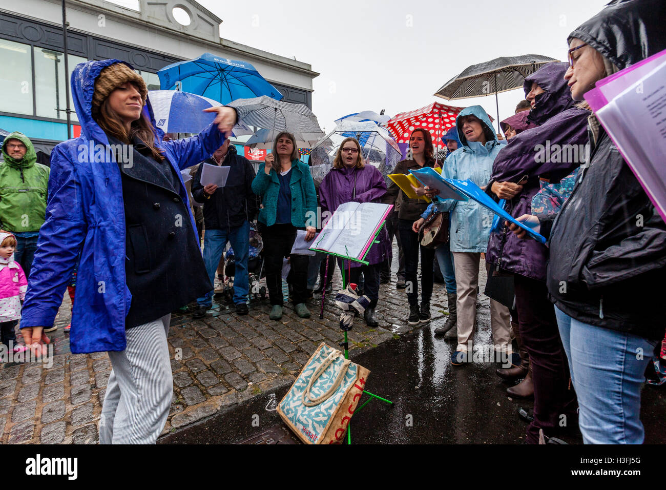 Une chorale communautaire d'effectuer sous la pluie, la High Street, Lewes, dans le Sussex, UK Banque D'Images