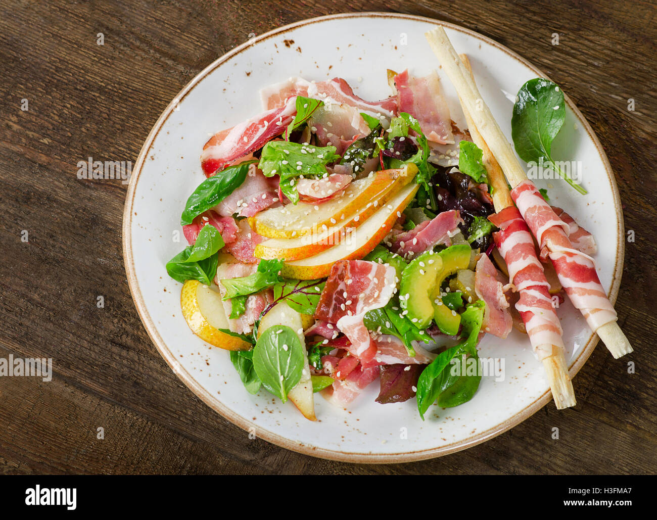 Salade fraîche à la pancetta et poire sur une table en bois. Vue d'en haut Banque D'Images