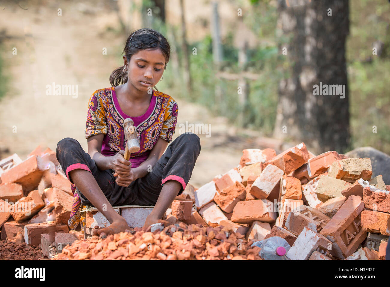 Chittagong, Bangladesh, le 25 février 2016 : jeune fille est en train de détruire les briques anciennes avec un marteau Banque D'Images