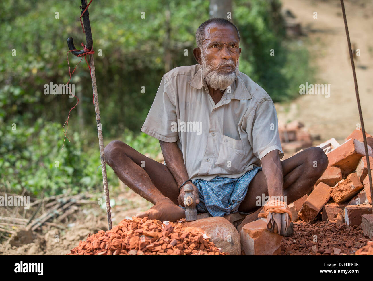 Chittagong, Bangladesh, le 25 février 2016 : Vieil homme détruire brique avec un marteau Banque D'Images