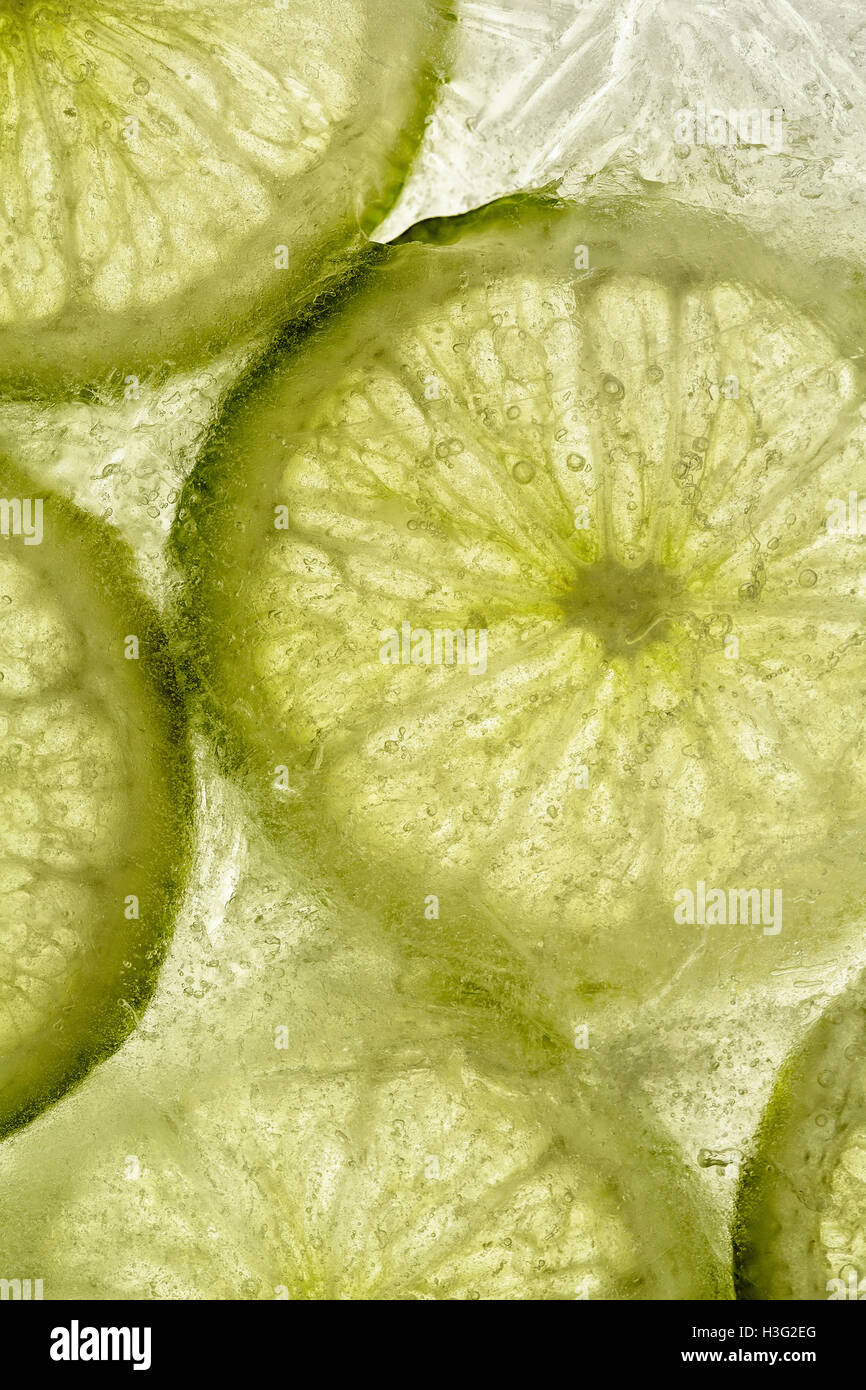 Un bloc de glace avec des tranches de fruits congelés de la Chaux Banque D'Images