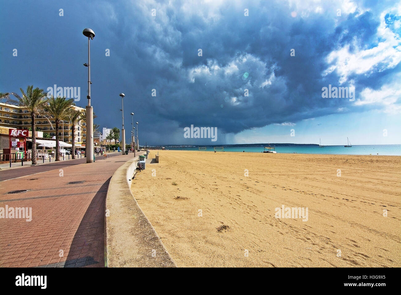 Filets de volley jaune et les joueurs sur la plage avec un sombre nuage d'orage et la pluie approche Banque D'Images