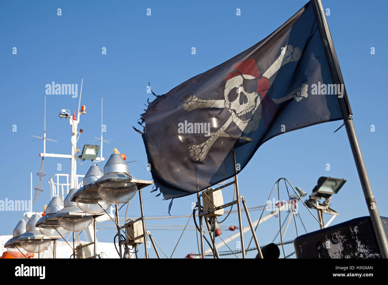 Un bateau de pêche battant pavillon de pirate Jolly Roger à Mithymna / Molivos à Lesbos / Lesbos en Grèce. Banque D'Images