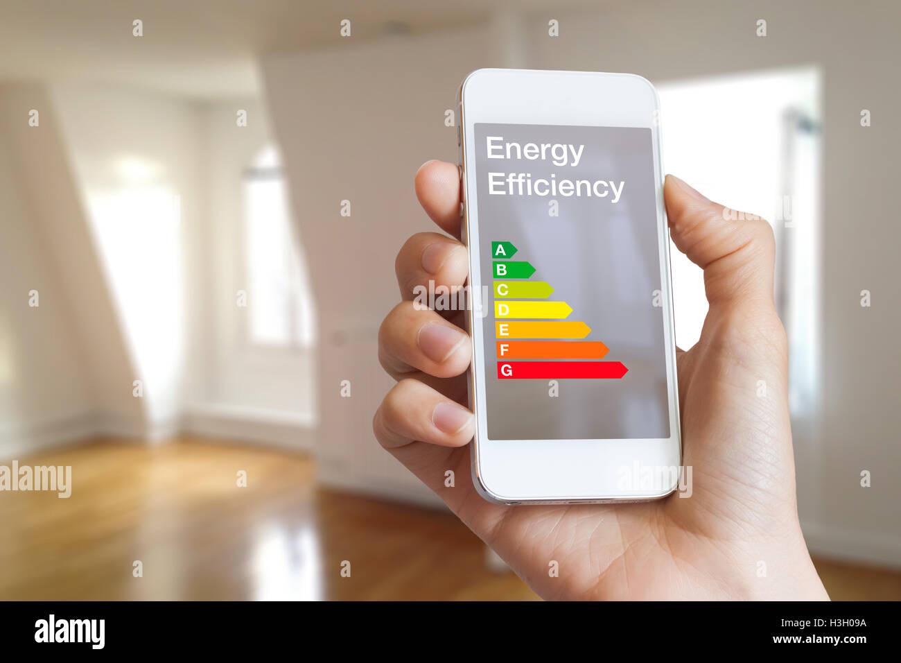 Cote d'efficacité énergétique sur l'application pour smartphone par femme agent immobilier et home intérieur en arrière-plan Banque D'Images