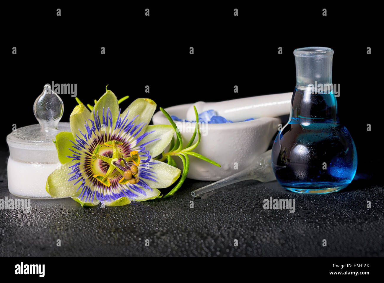 Spa magnifique composition de fleurs bleu passiflora, sel et mortier cosmétique bouteille de parfum sur pierres zen avec la rosée, Close up Banque D'Images