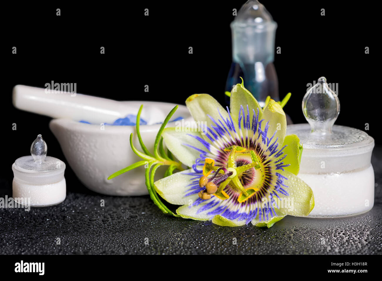 Beau spa de l'établissement blue passiflora, fleur de sel et de mortier cosmétique bouteille de parfum sur pierres zen avec la rosée, Close up Banque D'Images