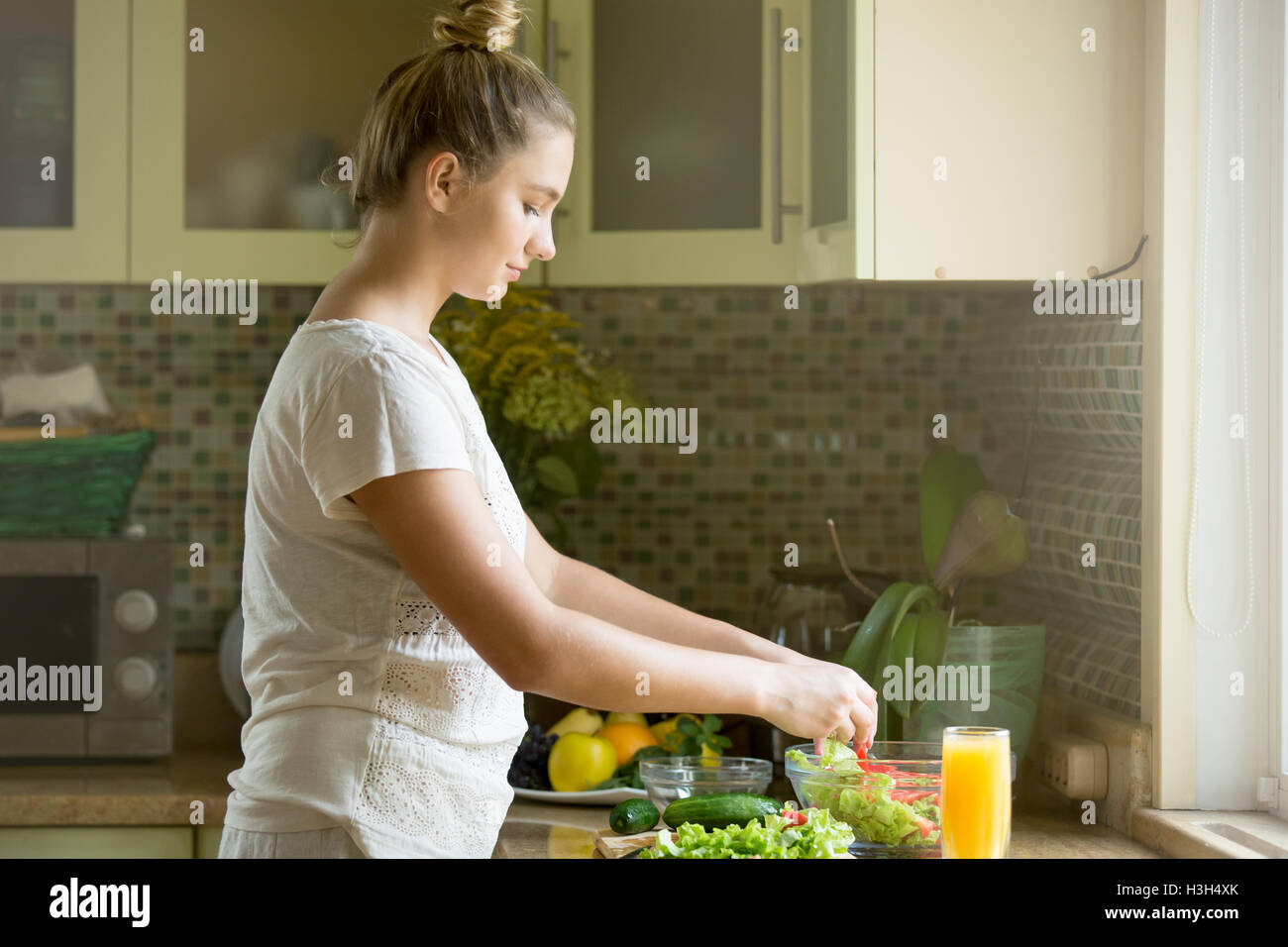 Portrait d'une jolie femme en salade fraîche sur le kitche Banque D'Images