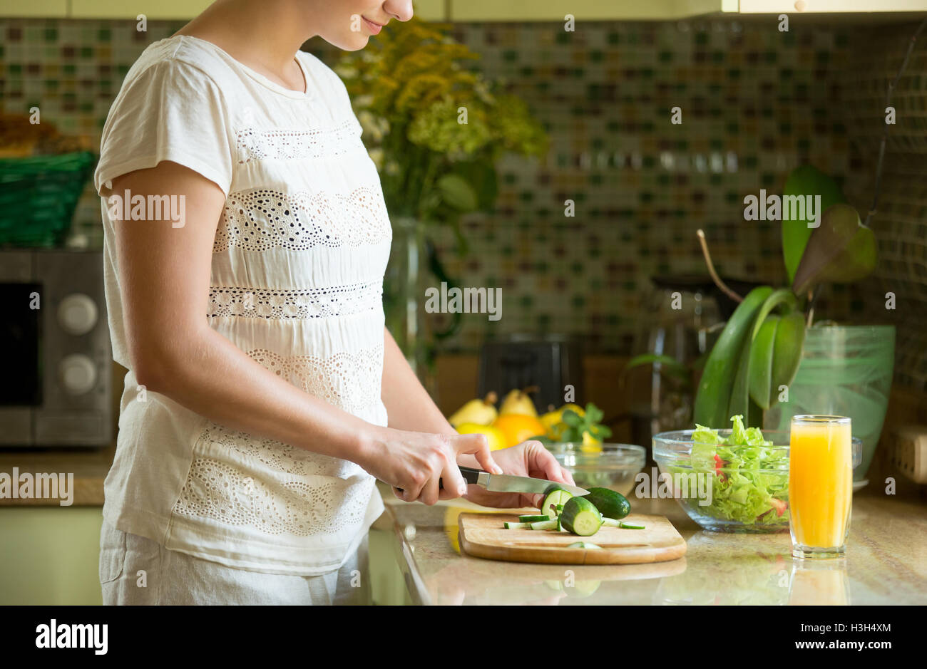 Coupe femme pour une salade de concombres sur la cuisine Banque D'Images