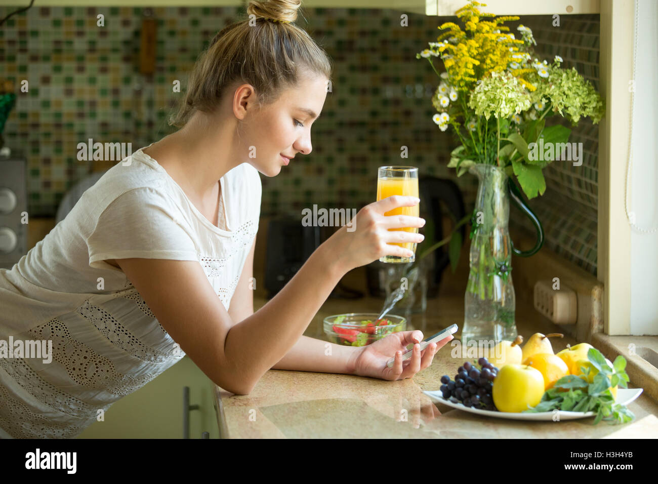 Portrait d'une jolie femme avec un jus et téléphone Banque D'Images