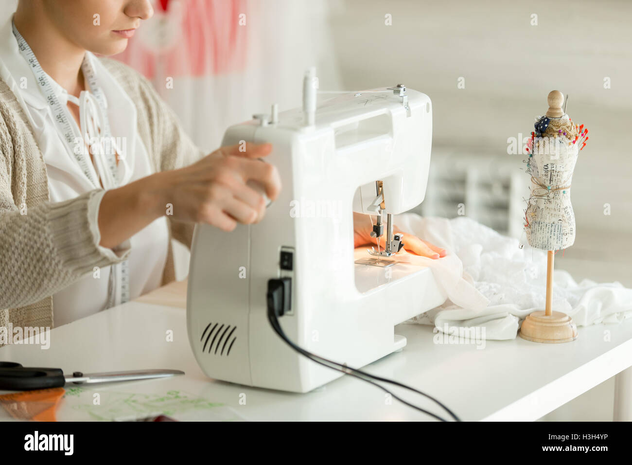 Femme au bord d'une machine à coudre Banque D'Images