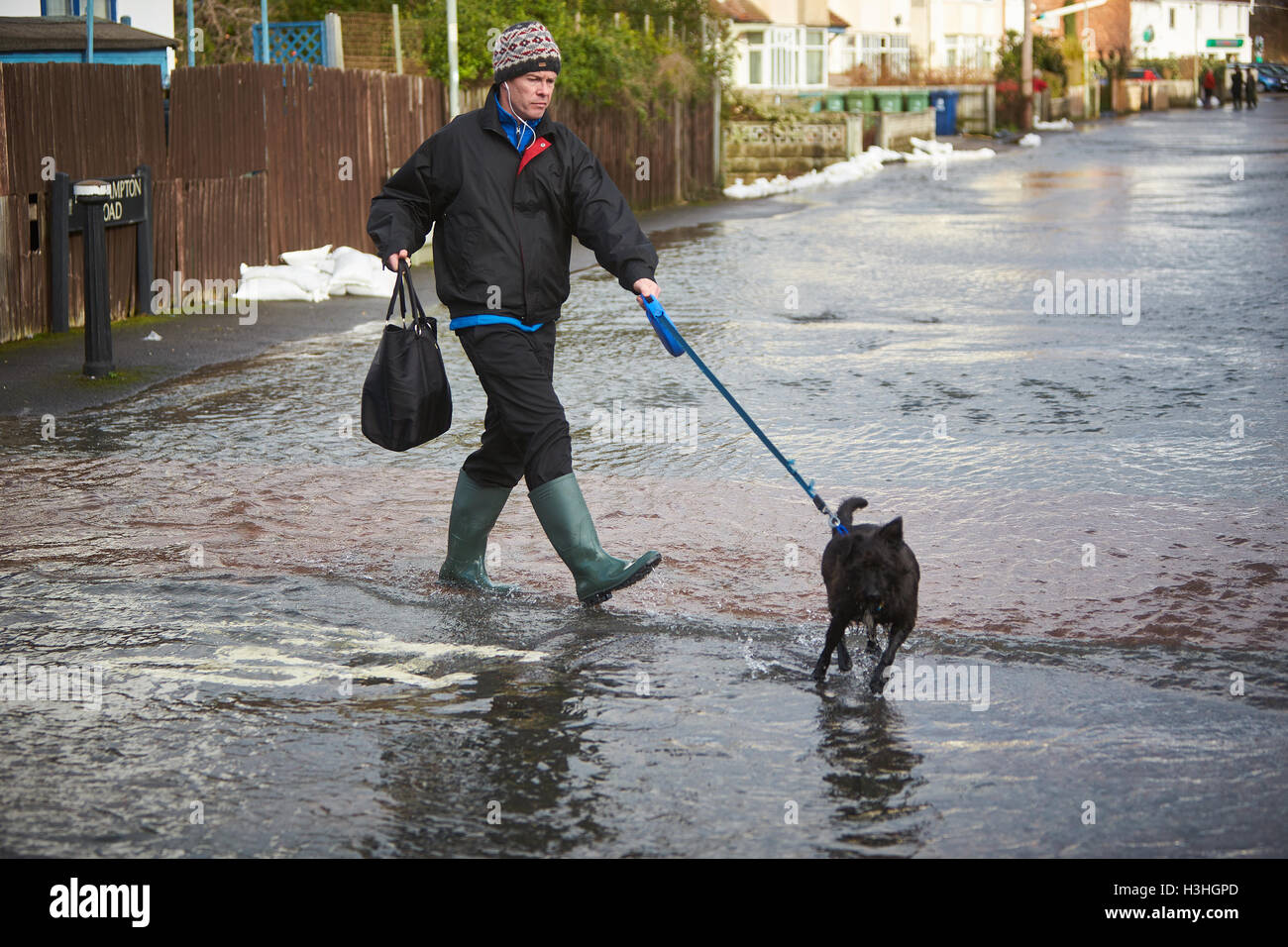Un homme promène son chien dans l'eau d'inondation à Oxford Banque D'Images