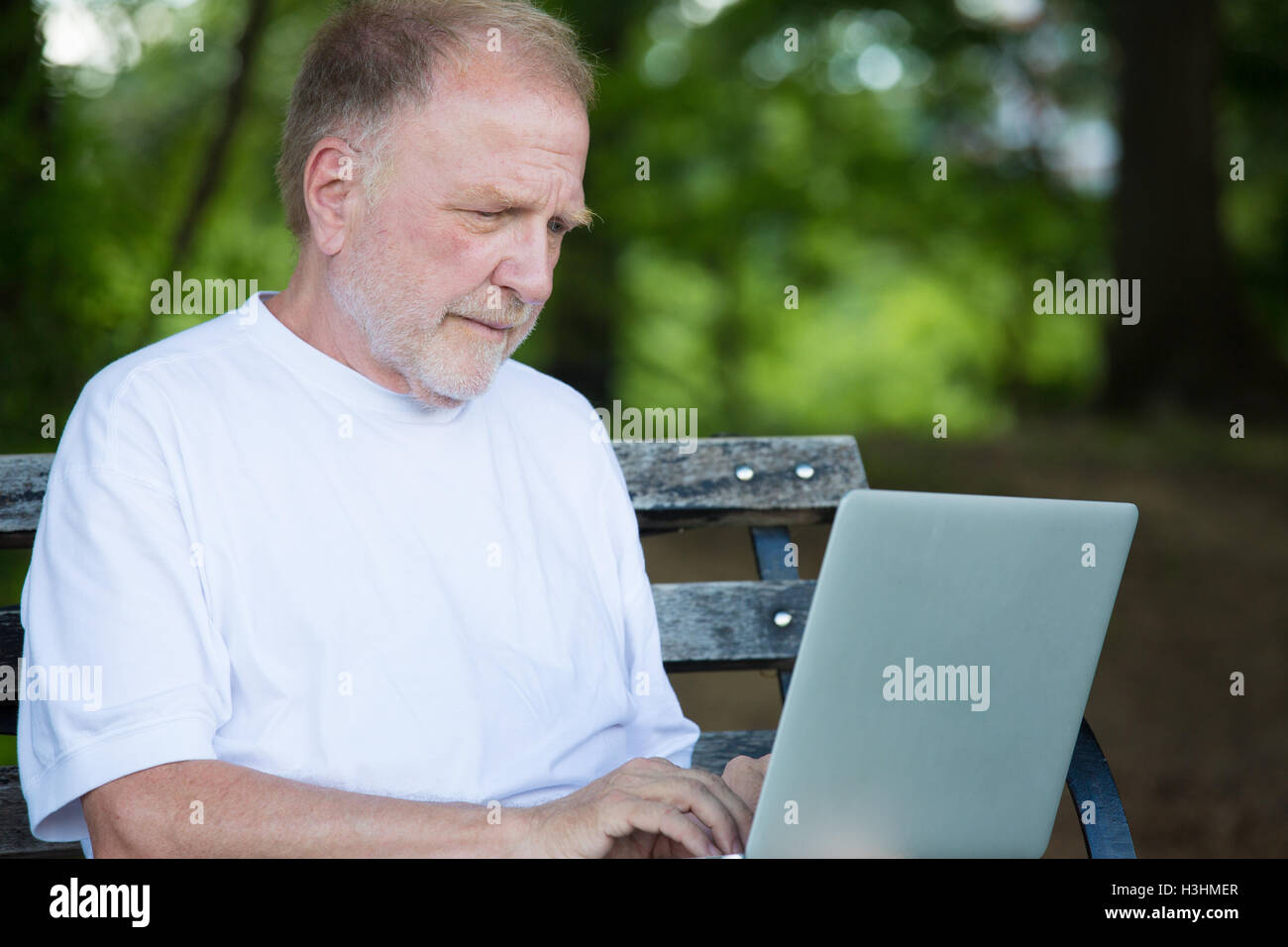 Closeup portrait, senior man en chemise blanche de taper, la navigation sur ordinateur portable ordinateur numérique Banque D'Images