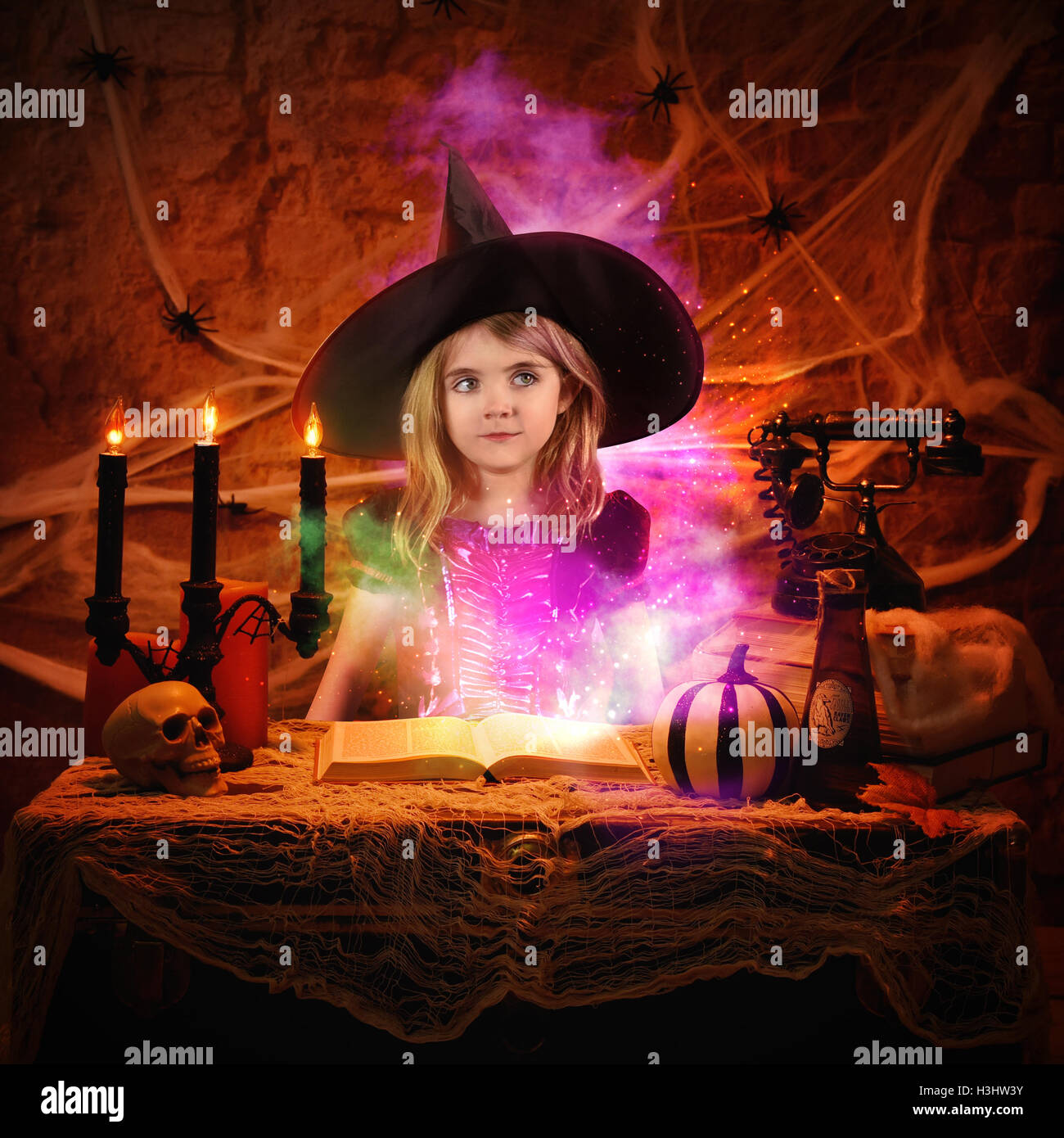 Une petite fille est habillé dans un costume wicth halloween avec un livre de sorts de magie pour une imagination ou scary story id Banque D'Images