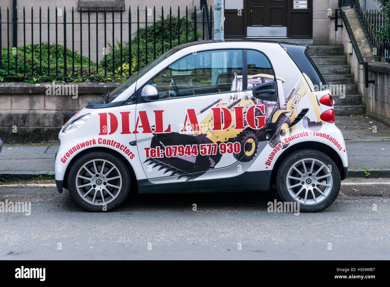 Annonce pour composer un Dig bases entrepreneurs sur le côté d'une voiture Smart fortwo. Banque D'Images