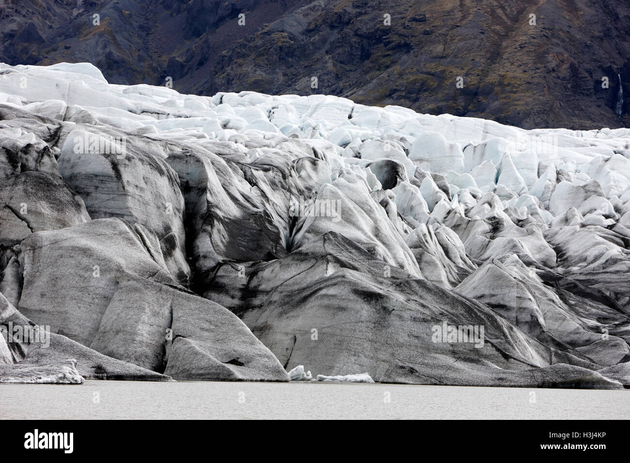 Fin de cendres couverts avec de l'eau de fonte du glacier Skaftafell Lac Parc national du Vatnajökull en Islande Banque D'Images