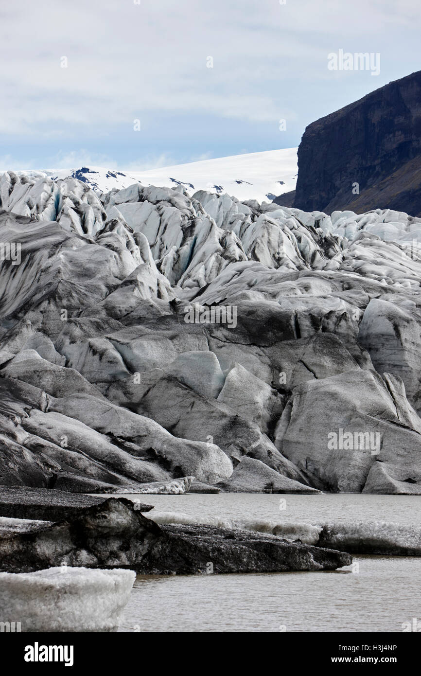 Couvert de cendres et de l'eau de fonte du glacier Skaftafell lagune glaciaire du parc national de Vatnajökull en Islande Banque D'Images