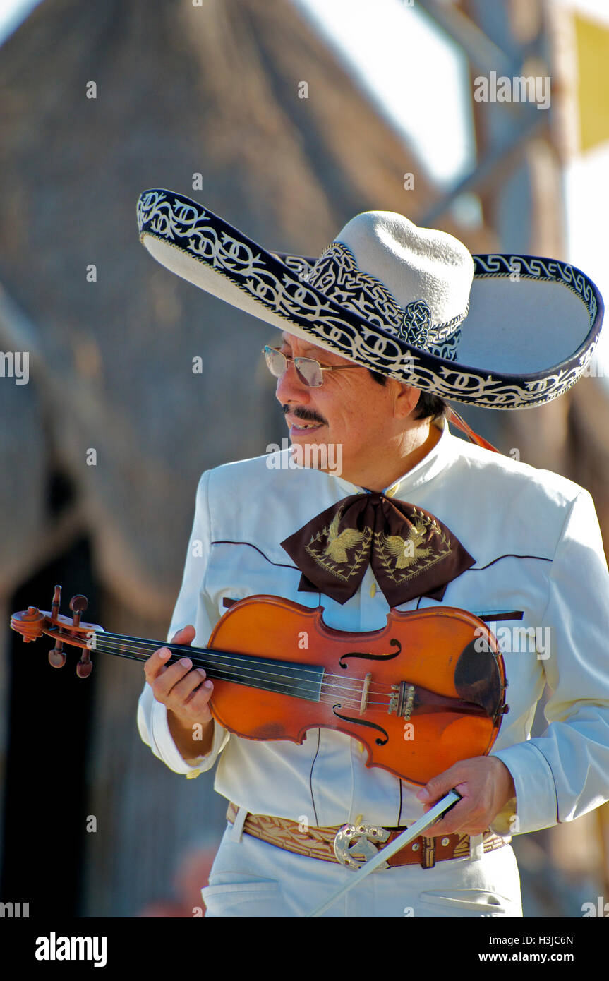 Mariachi Joueur de violon joue sur la plage ensoleillée au cours de Mariage portant un costume blanc et chapeau Sombrero avec godet d'or au Mexique Banque D'Images