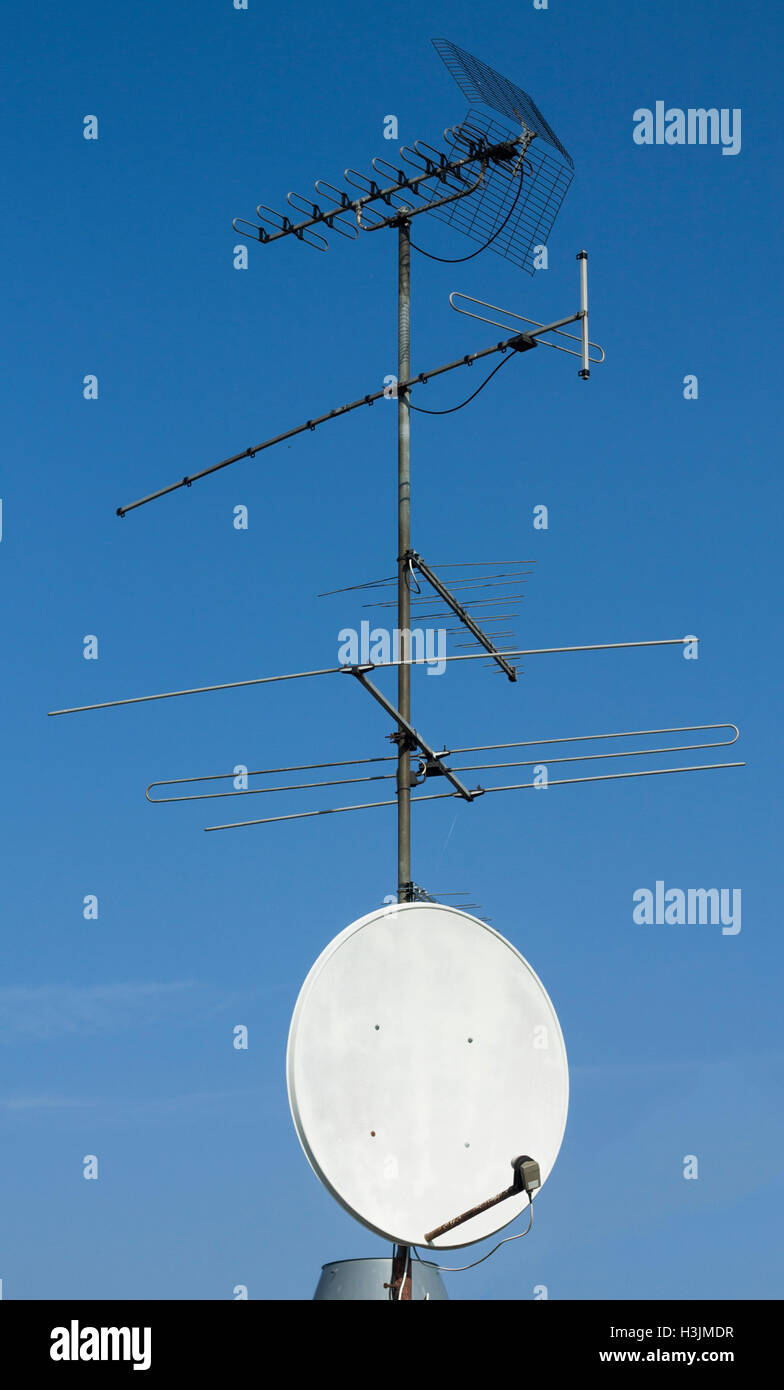 Antenne TV par satellite vertical sur fond de ciel bleu Banque D'Images