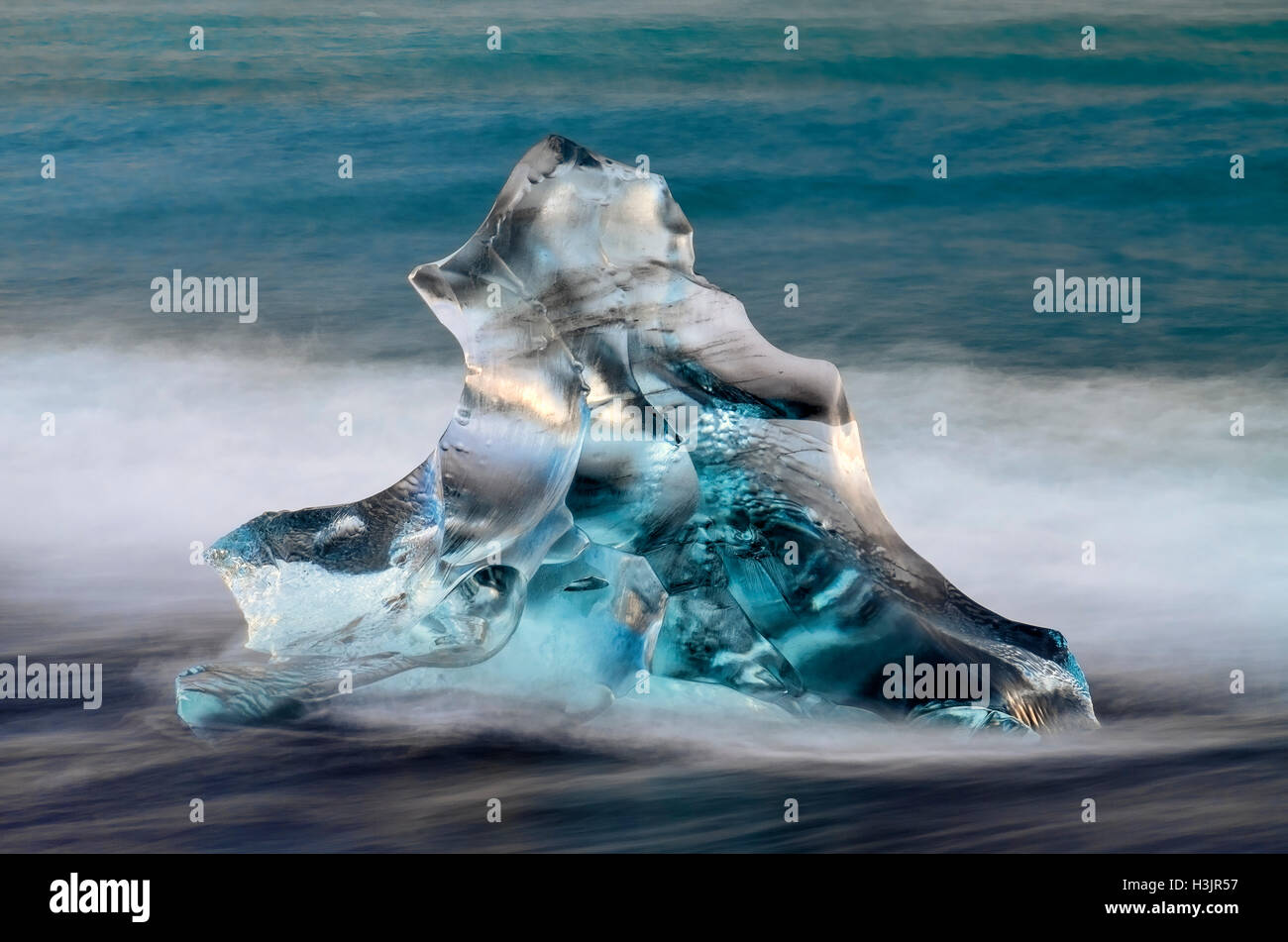 Iceberg en forme triangulaire sur Jokulsa plage volcanique, au lever du soleil, près de Johannesburg, le sud de l'Islande Banque D'Images