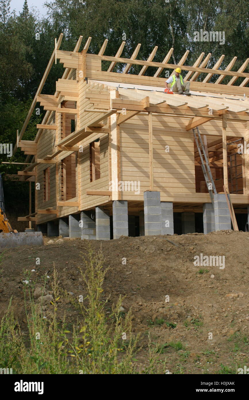 Un travailleur utilise un pistolet à ongles à gaz pour fixer des panneaux de toiture sur une maison en bois autoconstruit dans le Kent, au Royaume-Uni. Maison présentée dans le programme Grand Designs TV. Banque D'Images