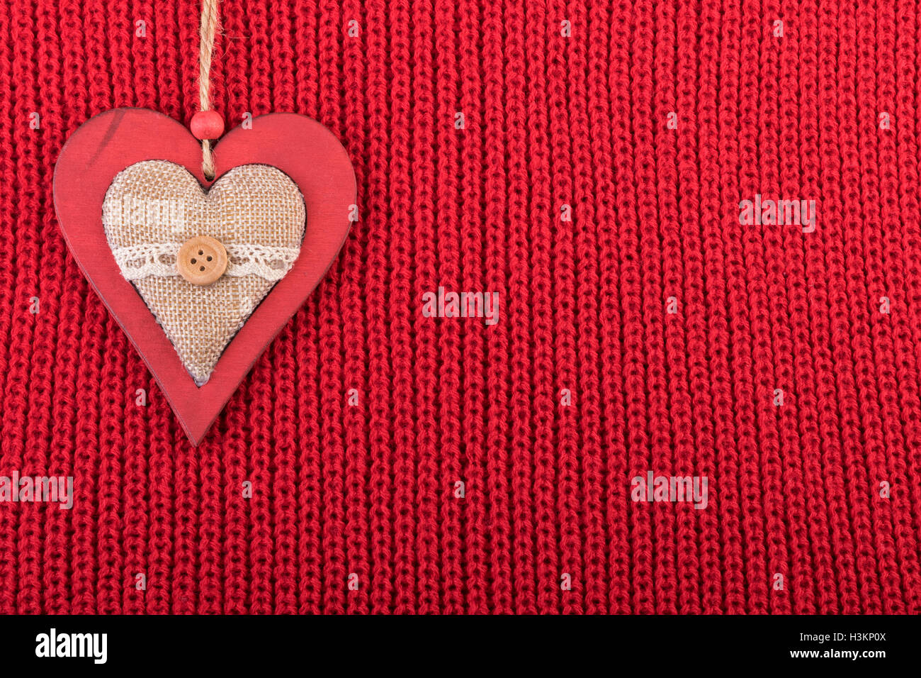 Décoration en bois Noël coeur sur un tissu de laine rouge. Rustic background with copy space. Banque D'Images