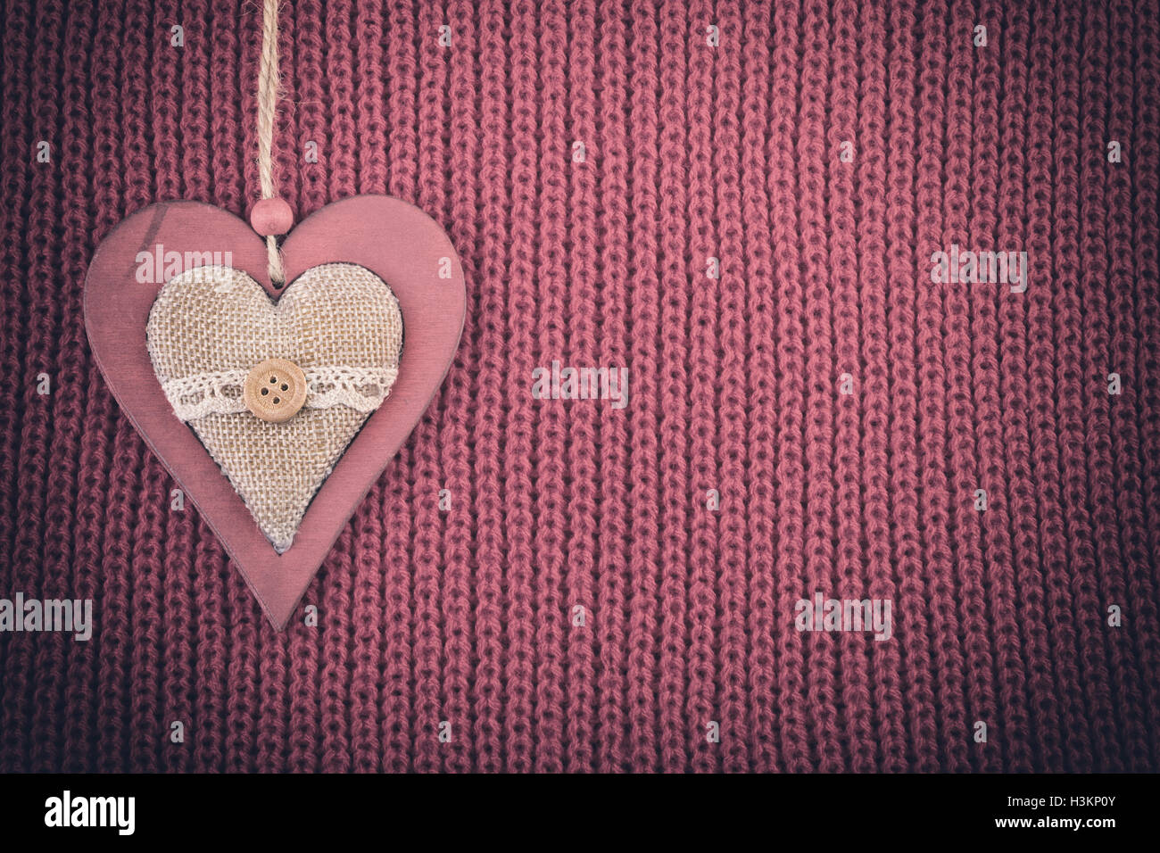 Coeur en bois sur des tricots de laine. Rustic vintage background couleur pâle vignette. Banque D'Images