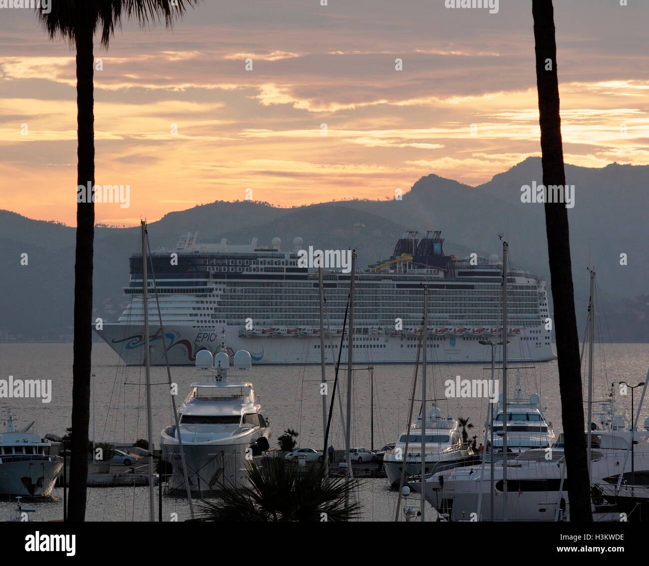 AJAXNETPHOTO. 2016. CANNES, FRANCE. - Côte D'AZUR RESORT - À L'OUEST À TRAVERS LA BAIE DE CANNES AVEC Norwegian Cruise Line's Norwegian Epic CRUISE SHIP ANCRÉ DANS LA BAIE AU COUCHER DU SOLEIL ET SUPER YACHTS ET VEDETTE À MOTEUR AMARRÉ DANS LA MARINA DE PORT PIERRE CANTO (premier plan). PHOTO:JONATHAN EASTLAND/AJAX REF:GX160710 6440 Banque D'Images