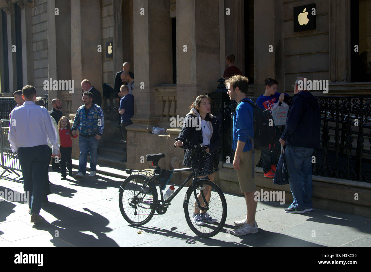 Scène de rue de Glasgow apple store un garçon une fille et un vélo Banque D'Images