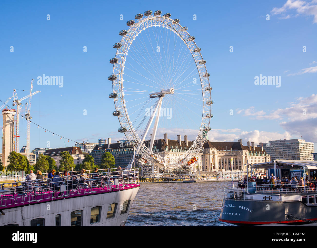 Les gens de boire et manger sur le bateau restaurants sous l'oeil de Londres pendant la croisière sur la Tamise Banque D'Images