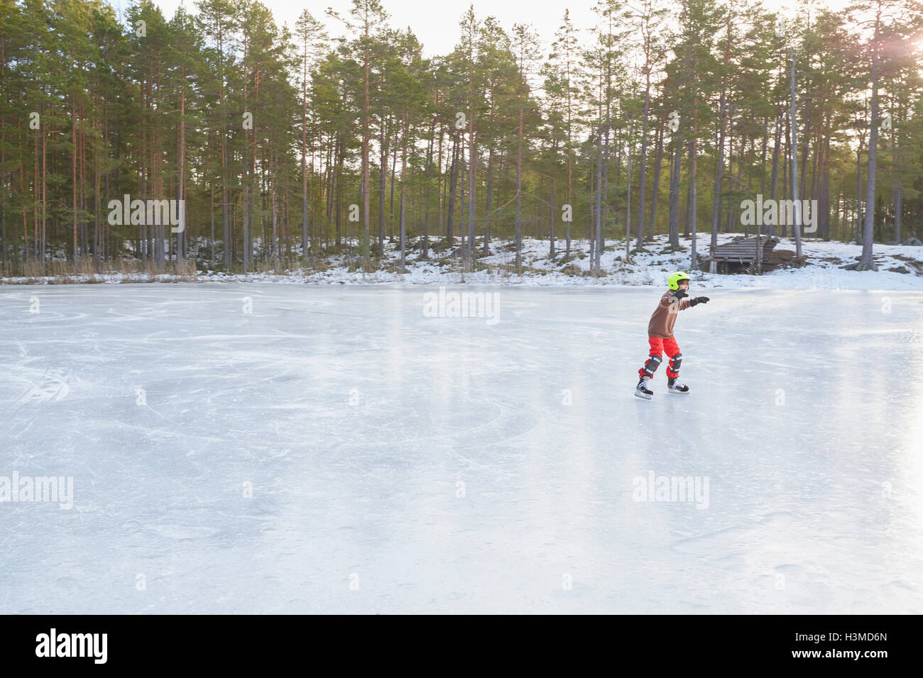Boy le patin à glace sur un lac gelé, Gavle, Suède Banque D'Images