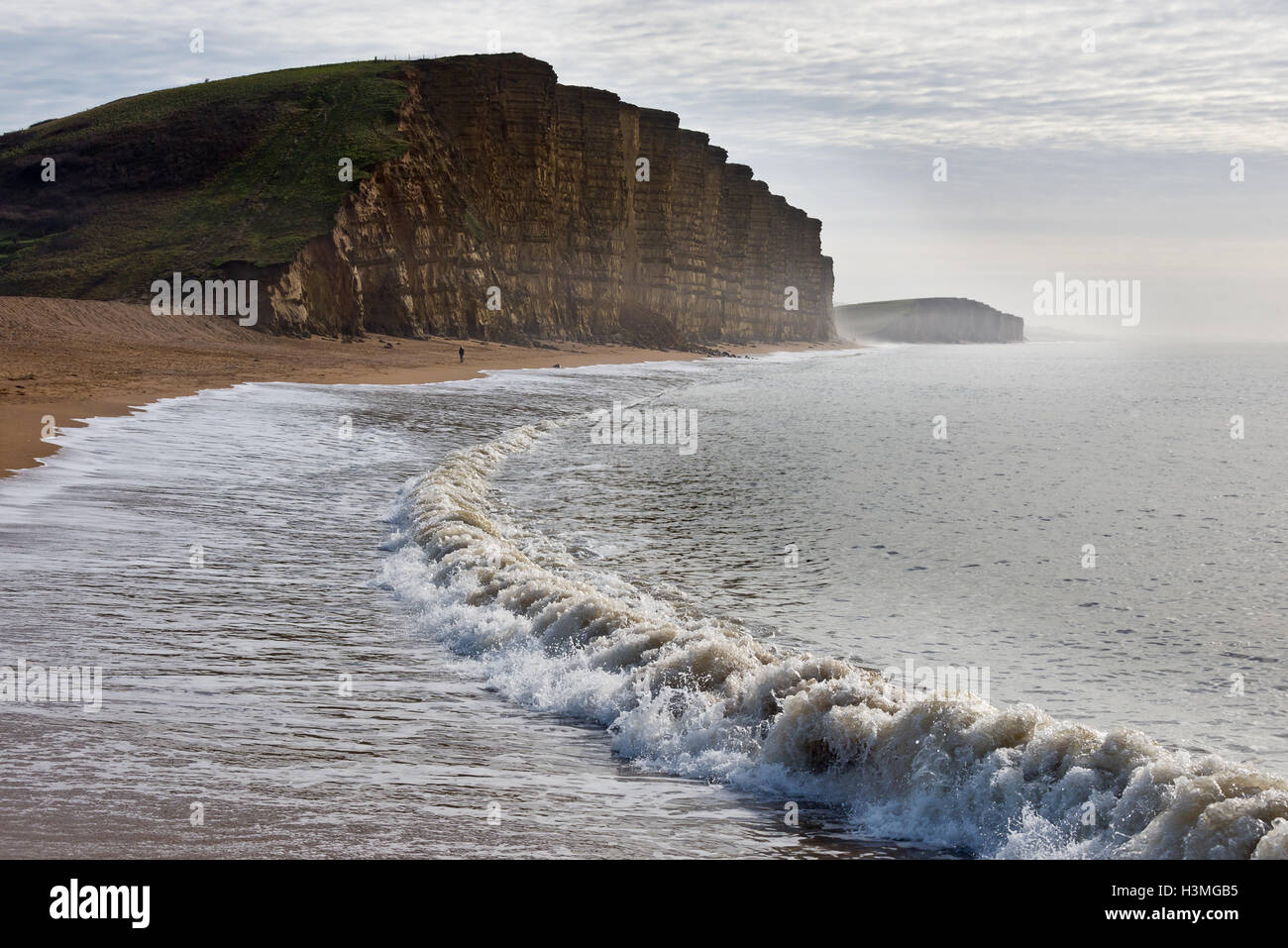 Vue d'une soirée de West Bay pier à la recherche le long de la plage vers l'East Cliff Burton et Falaise sur Dorsets côte jurassique Banque D'Images