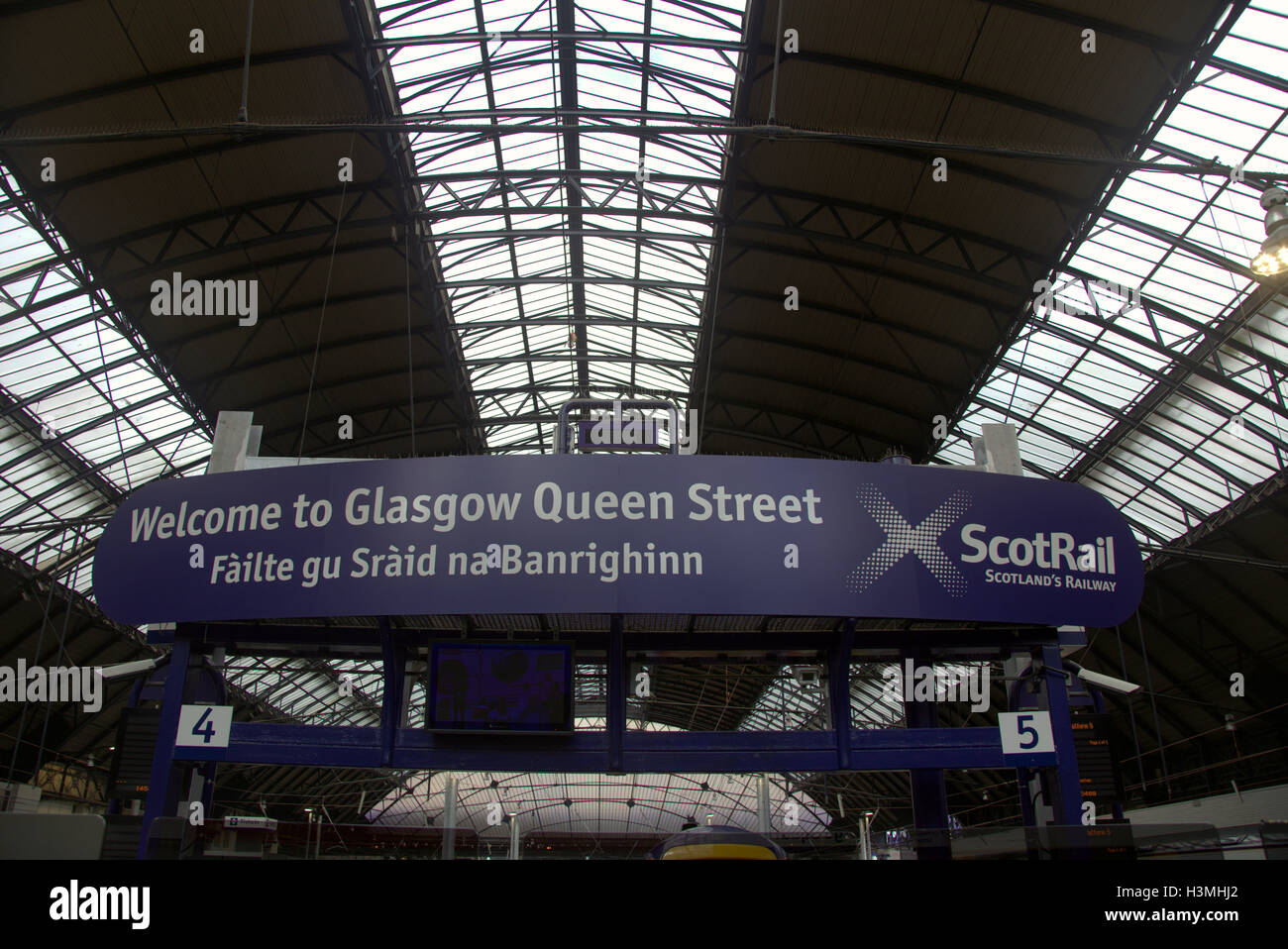 Touristiques de Glasgow en déplacement de train scène avec station de traduction gaélique Banque D'Images