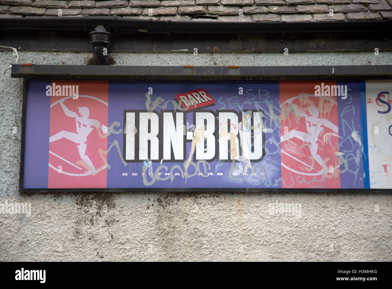 L'irn bru graffiti vintage vandalisée la culture écossaise signe sur l'icône bâtiment délabré Banque D'Images
